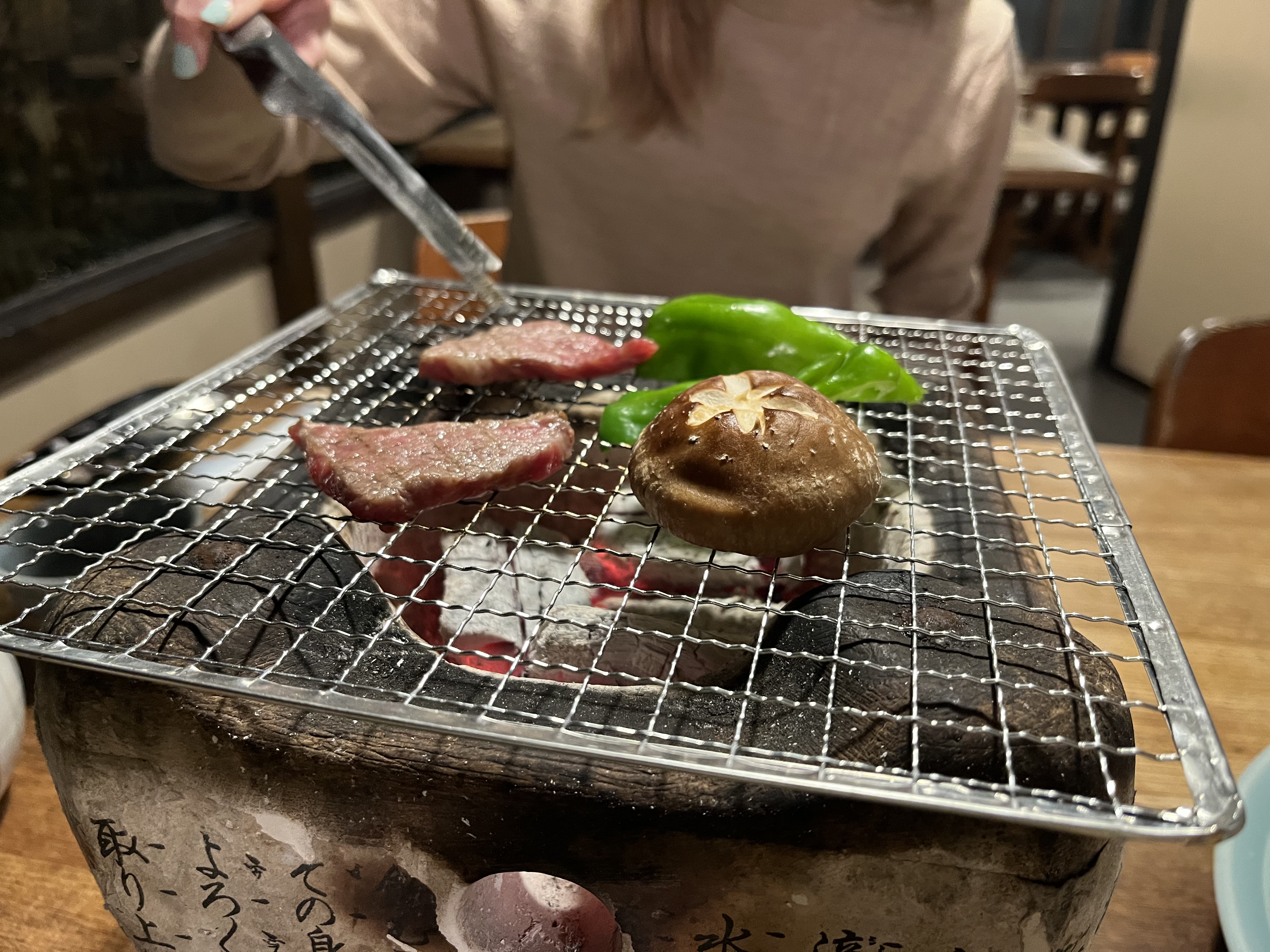 Wagyu beef, mushroom and peppers on a tabletop charcoal grill